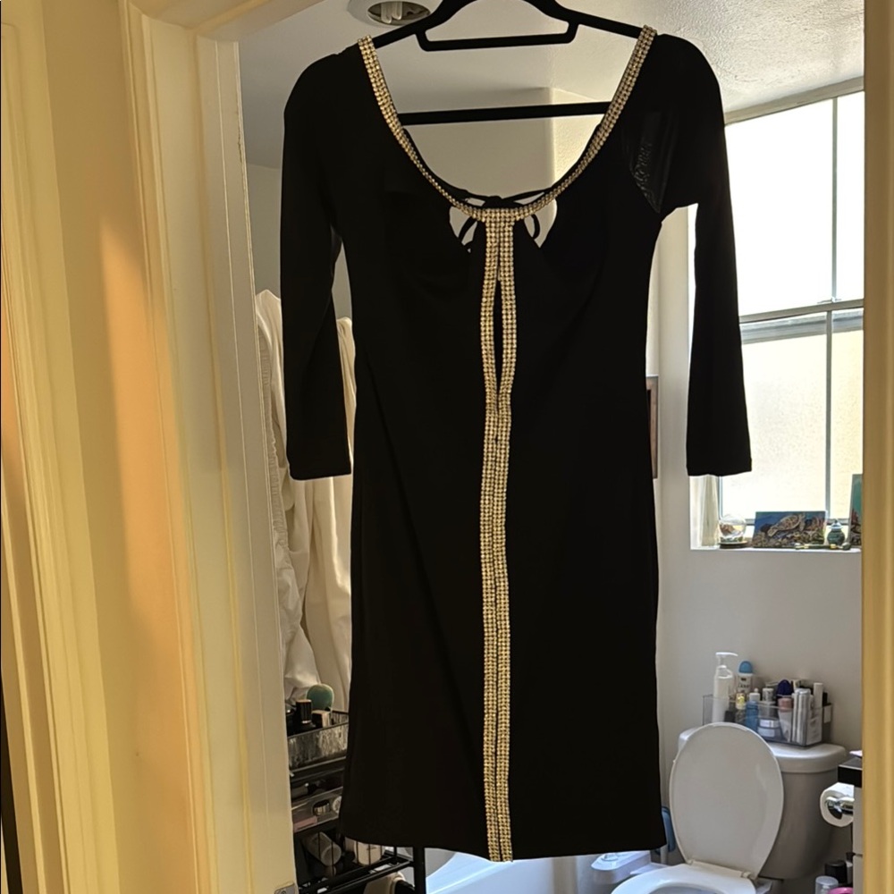 Stunning form-fitting black dress with rhinestone accents and 3/4 Sleeves